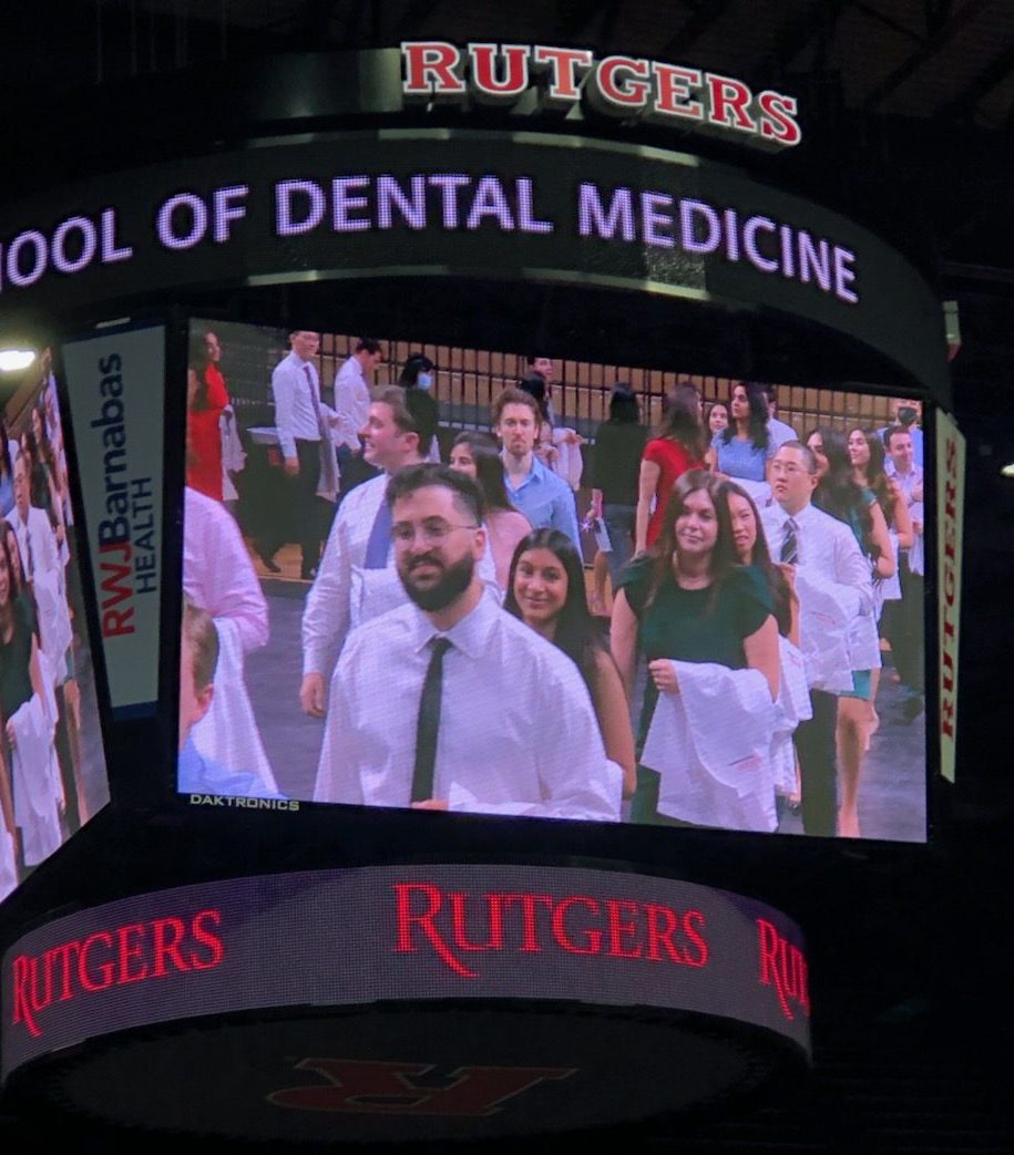 RSDM students at April 6 white coat ceremony, their images projected on a giant screen.